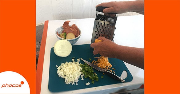 Person grating cheese on a chopping board