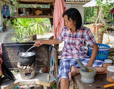 Woman cooking with clay pot and firewood outdoor