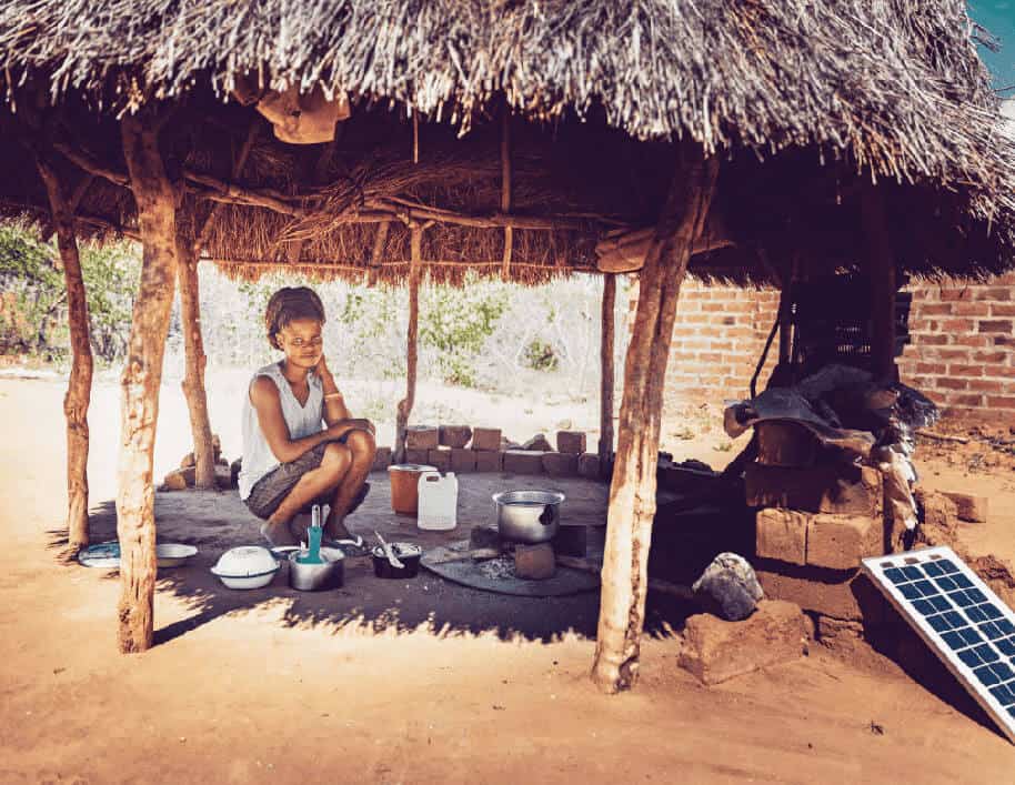 African woman in hut with solar panel